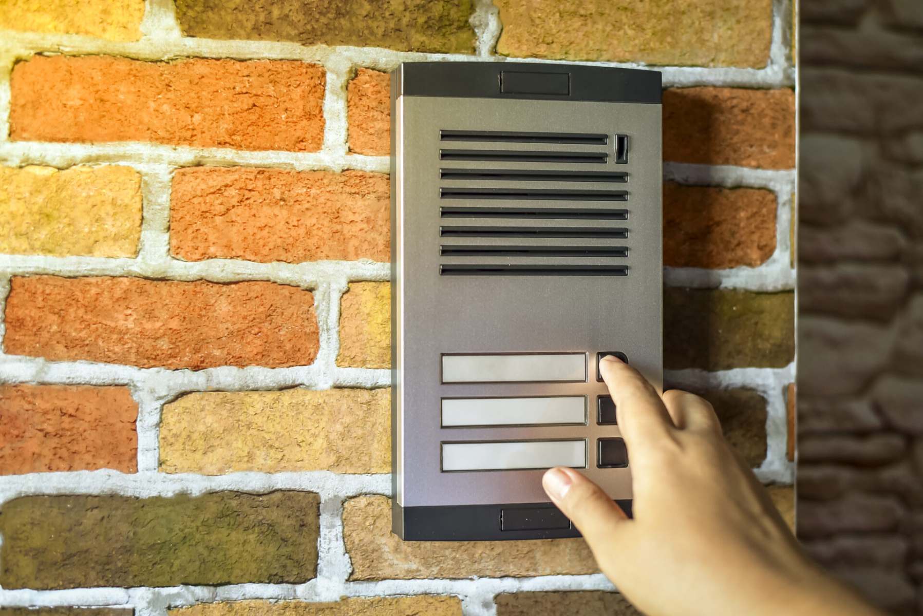 close up of woman using intercom at building entra