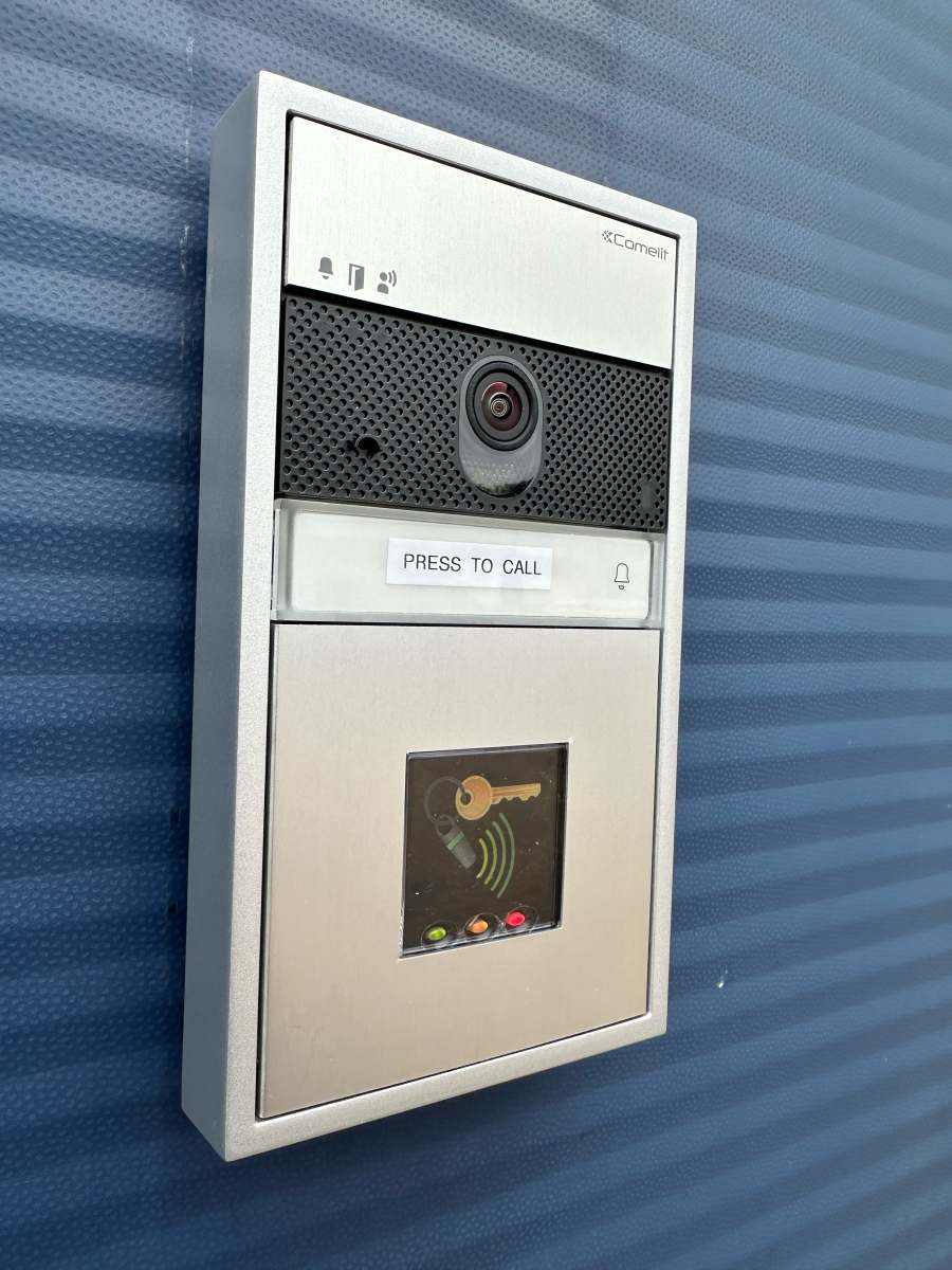 close up of woman using intercom at building entra